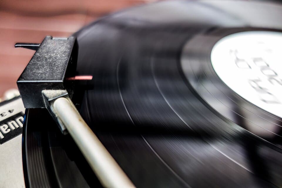 Bras de lecture posé sur un disque vinyle noir qui tourne